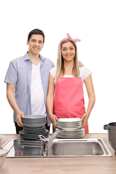 Happy young couple with stacks of clean plates — Stock Photo, Image