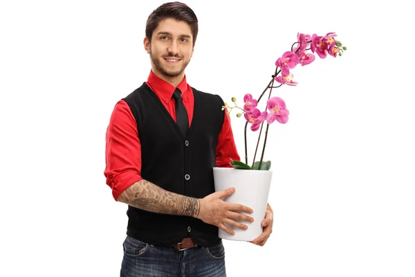 Wytatuowany facet trzyma Orchidea kwiat w doniczce — Zdjęcie stockowe