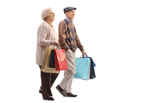 Casal sênior com sacos de compras andando — Fotografia de Stock