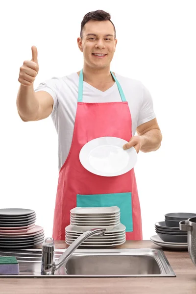 Man showing clean plate and making thumb up gesture — Stock Photo, Image