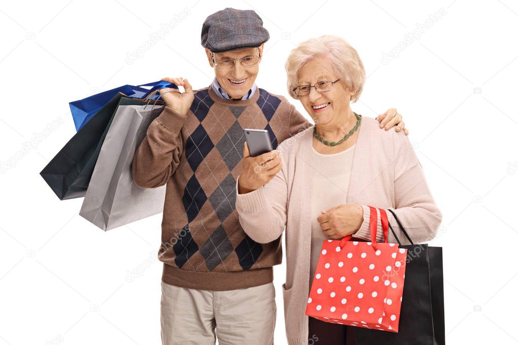 Seniors with shopping bags looking at a mobile phone