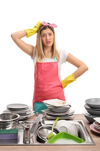 Vrouw achter een aanrecht gevuld met vieze borden — Stockfoto