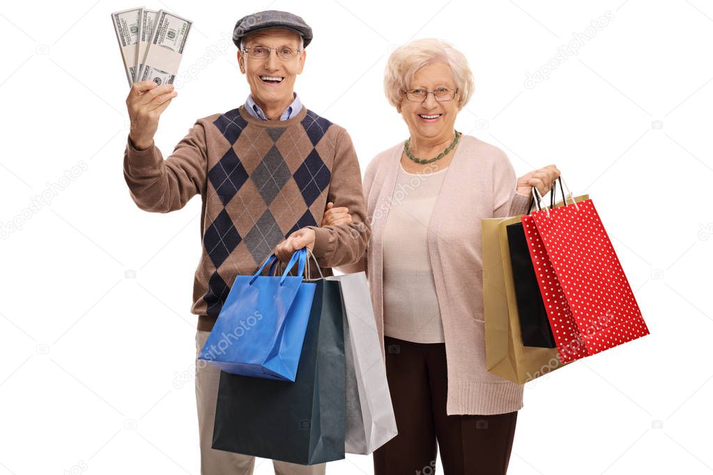 Cheerful seniors with bundles of money and shopping bags
