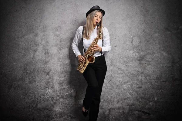 Привлекательная девушка, играющая на саксофоне — стоковое фото
