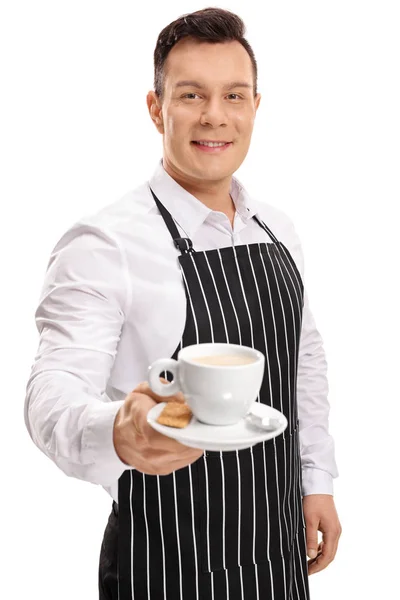 Ung servitör erbjuder en kopp kaffe — Stockfoto