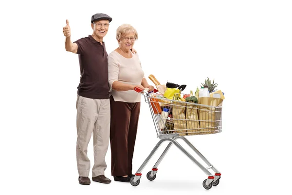 Anziani con un carrello della spesa dando pollici in su — Foto Stock