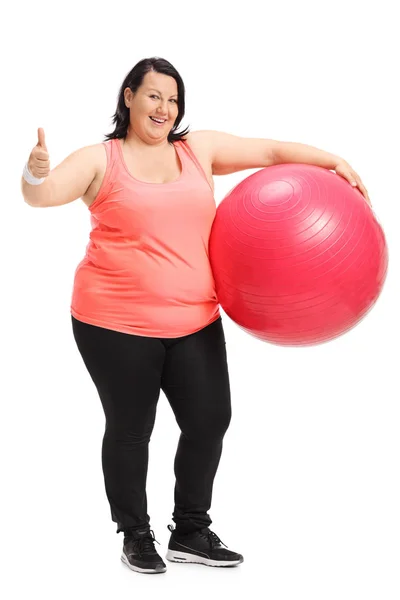 Wanita kelebihan berat badan memegang bola pilates dan membuat ibu jari up tanda — Stok Foto