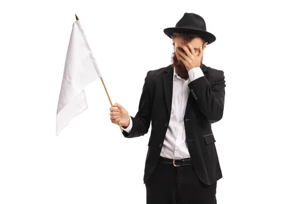 Człowiek z białą flagą trzymając głową z niedowierzaniem — Zdjęcie stockowe