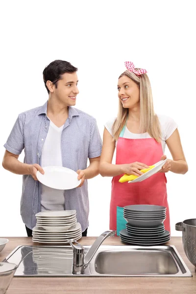 Pareja limpiando platos juntos y sonriendo —  Fotos de Stock