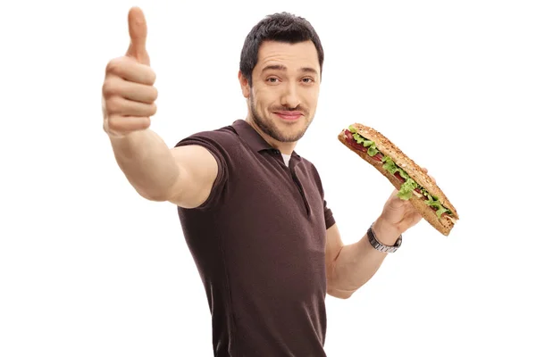 Человек с бутербродом, делающий большой палец вверх — стоковое фото