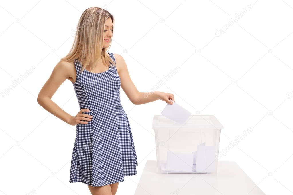 Female voter casting a vote into a ballot box