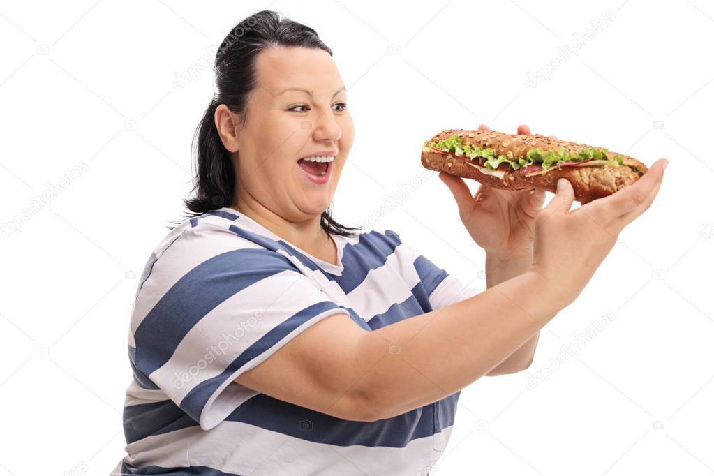Happy overweight woman having a sandwich
