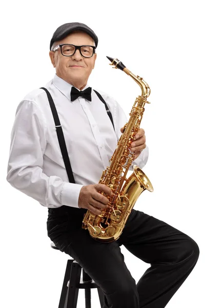 Jazz-muzikant met een saxofoon zittend op een stoel — Stockfoto