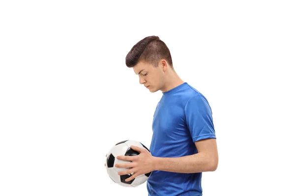 Грустный футболист-подросток с футбольным мячом — стоковое фото