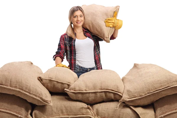 Agricultora detrás de una pila de sacos de arpillera —  Fotos de Stock