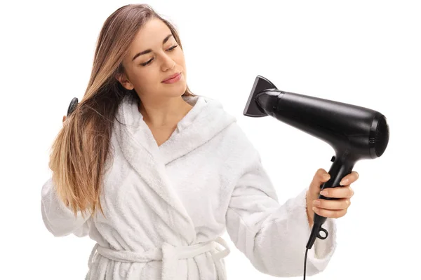 Girl in a bathrobe blowing her hair with a hairdryer — Stock Photo, Image