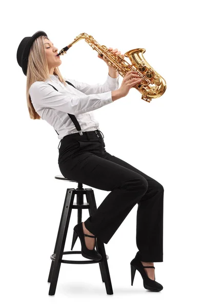 Женщина сидит на стуле и играет на саксофоне — стоковое фото