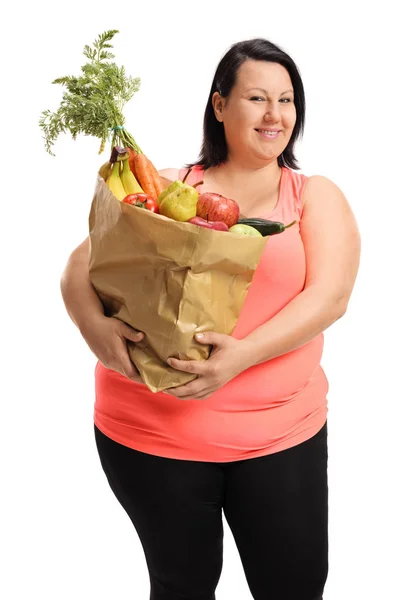 Vrouw met een papieren zak gevuld met groenten en fruit — Stockfoto