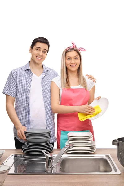 Pareja joven limpiando platos juntos —  Fotos de Stock