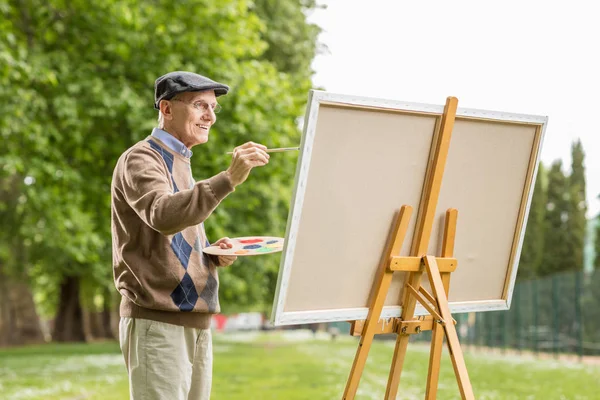 Homme âgé peignant sur une toile — Photo