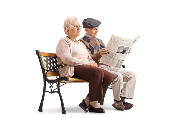 Старшеклассники сидят на скамейке, один из них читает газету. — стоковое фото