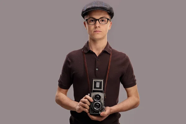 Menino em uma roupa vintage segurando uma câmera velha — Fotografia de Stock
