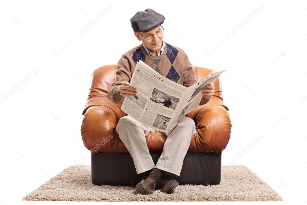 man sitting in an armchair and reading a newspaper