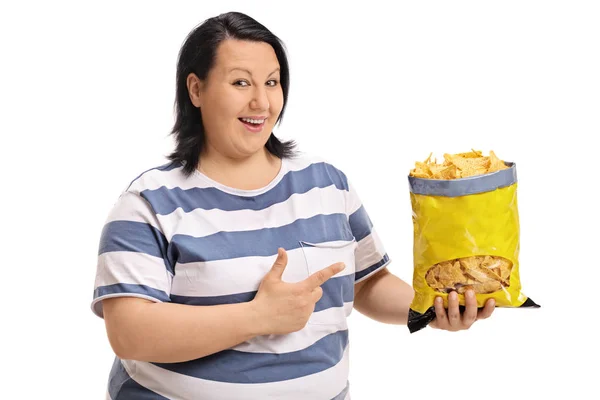 Mujer con sobrepeso sosteniendo una bolsa de patatas fritas y señalando — Foto de Stock