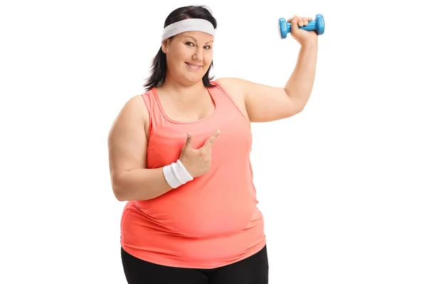 Mulher com excesso de peso levantando um haltere e apontando — Fotografia de Stock
