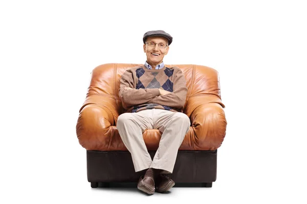 Elderly man sitting in a leather armchair — Stock Photo, Image