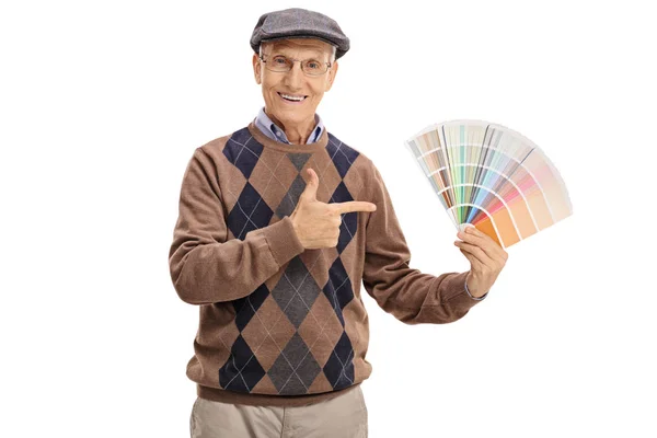 Senior tenant un échantillon de couleur et pointant — Photo