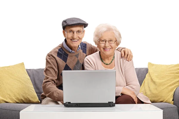 老年夫妇同坐在沙发上的一台笔记本电脑 — 图库照片