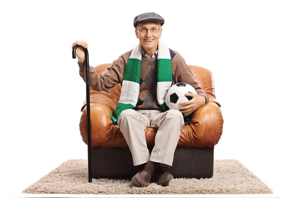 Ouderen voetbal fan zitten in een lederen fauteuil — Stockfoto