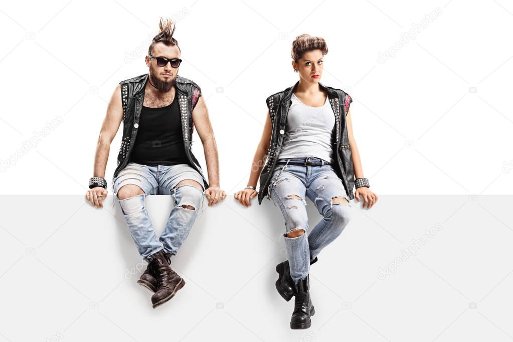 Male and female punkers sitting on a panel