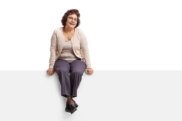 Senior vrouw zitten op een paneel — Stockfoto