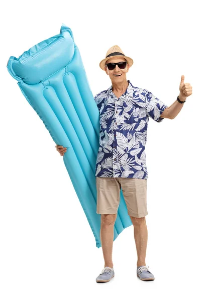 Turista con un colchón de aire haciendo gesto pulgar hacia arriba — Foto de Stock