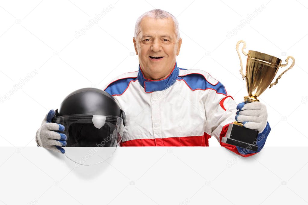 car racer with golden trophy and helmet behind panel