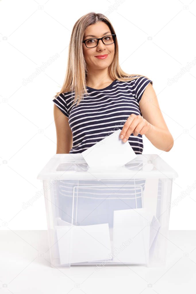 Female voter casting a vote into a ballot box