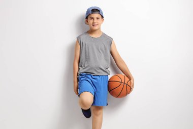 Bir duvara yaslanmış basketbol çocukla
