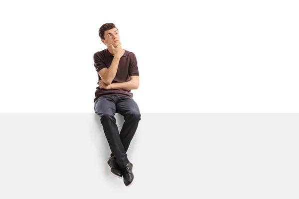 Adolescente pensativo sentado em um painel — Fotografia de Stock