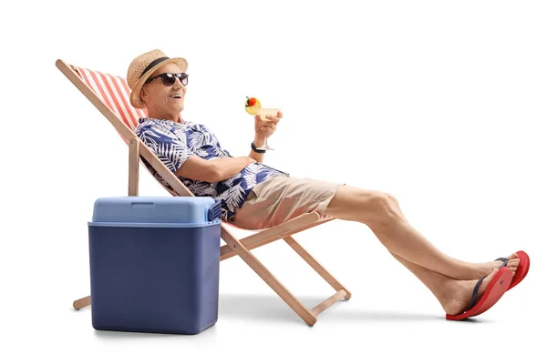 Turista idoso com um coquetel sentado em uma cadeira de praia — Fotografia de Stock