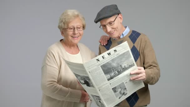 Пенсионеры, читающие газету — стоковое видео