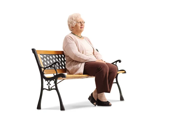 Femme âgée assise sur un banc et regardant ailleurs — Photo