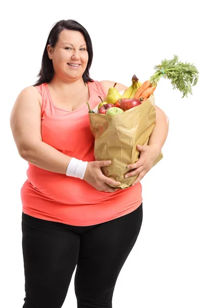 Vrouw met papieren zak gevuld met groenten en fruit — Stockfoto