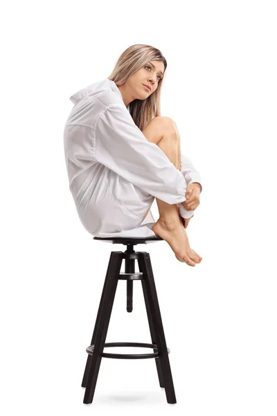 Triste jovem mulher sentada em uma cadeira — Fotografia de Stock
