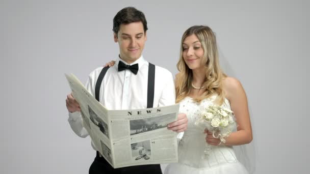 Νεόνυμφο ζευγάρι διαβάζει μια εφημερίδα — Αρχείο Βίντεο