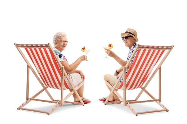 Elderly tourists with cocktails sitting in deck chairs — Stock Photo, Image