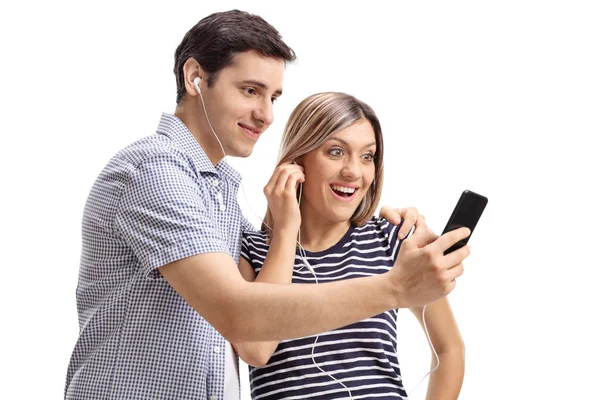 Pasangan muda mendengarkan musik di telepon — Stok Foto