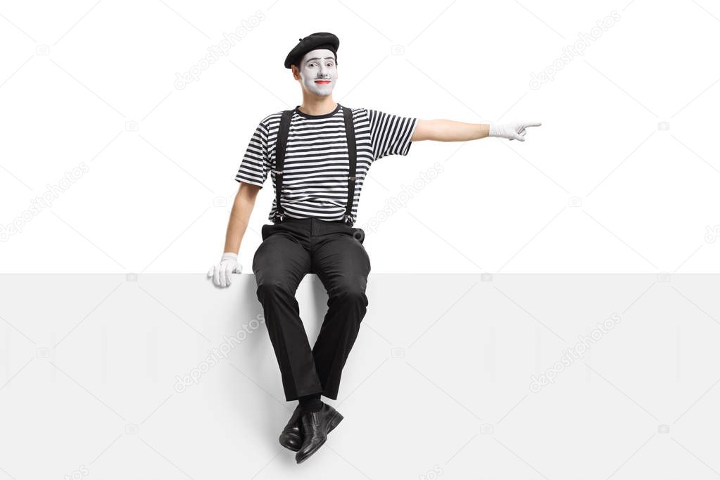 Mime sitting on a panel and pointing right