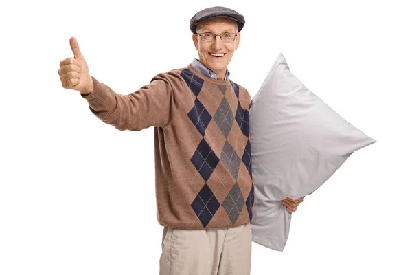 Senior with a pillow making a thumb up gesture — Stock Photo, Image